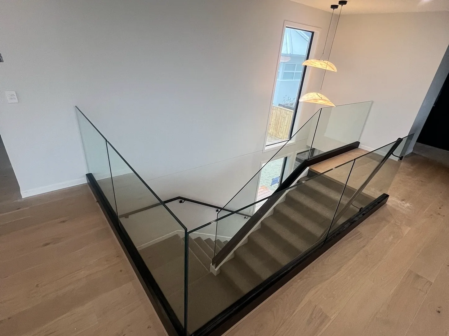 Glass balustrade around an upstairs landing with a timber floor