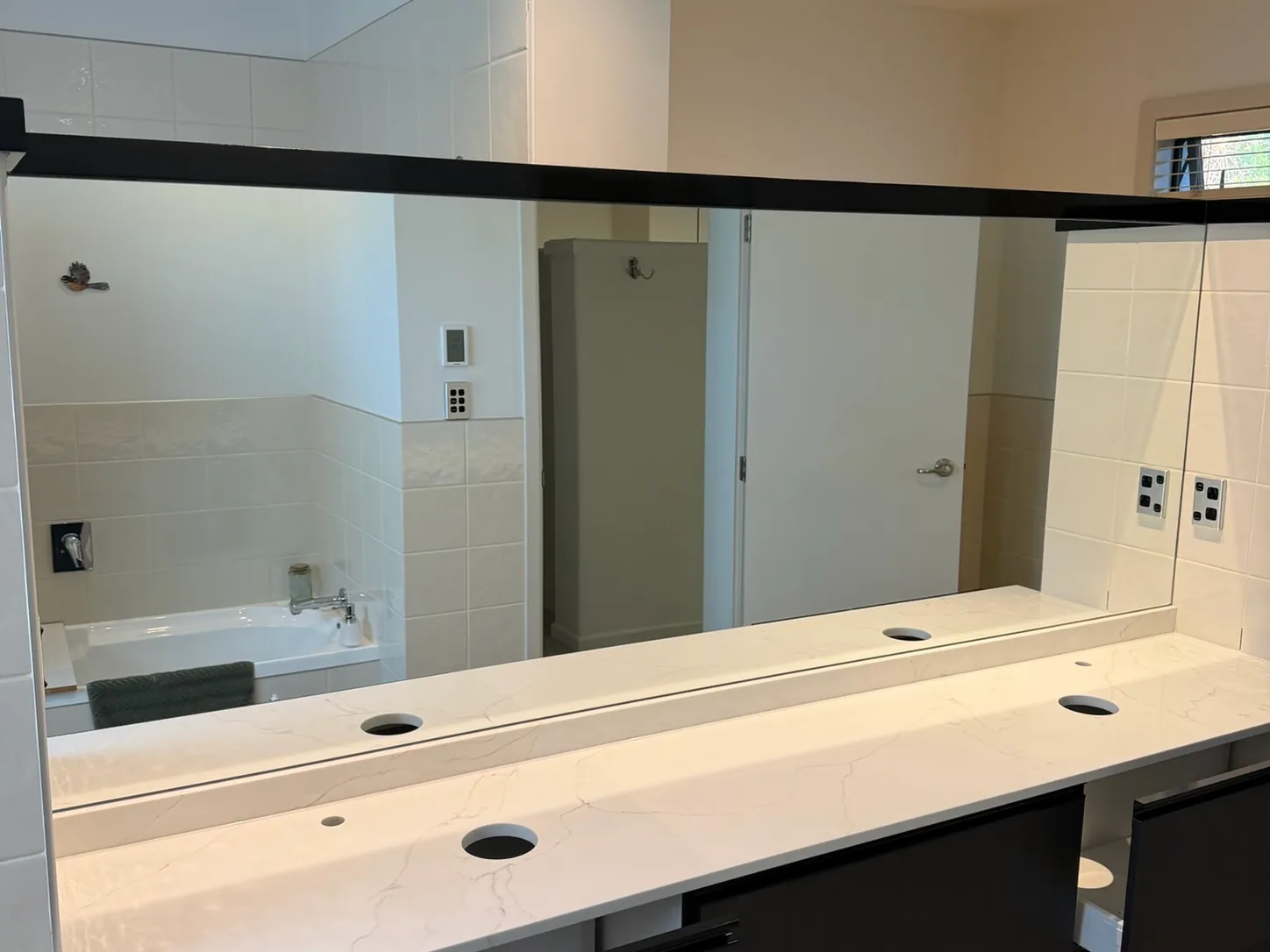 Wide mirror fitted the full length of a double vanity
