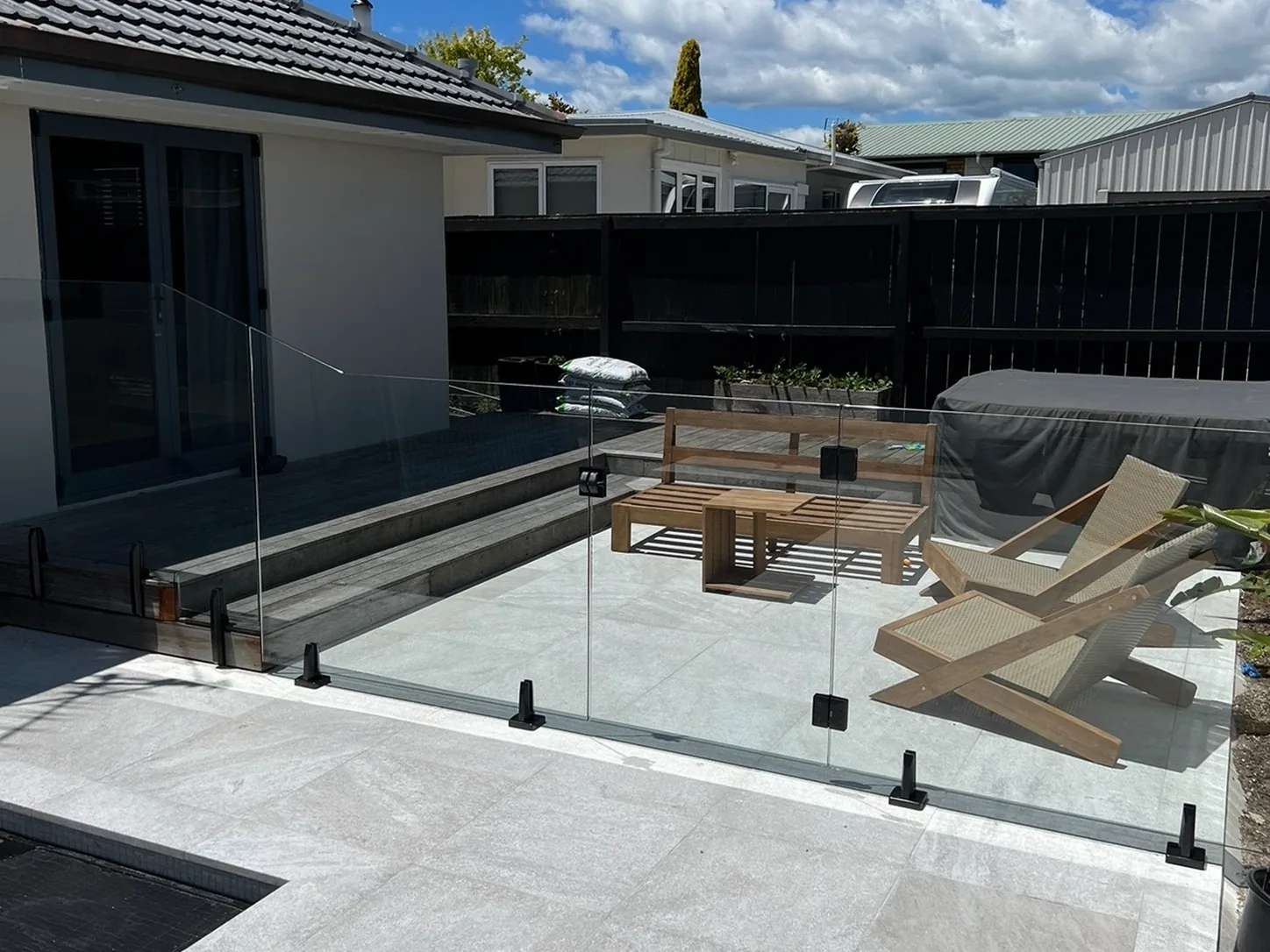 Frameless glass pool fencing around a courtyard pool and seating area