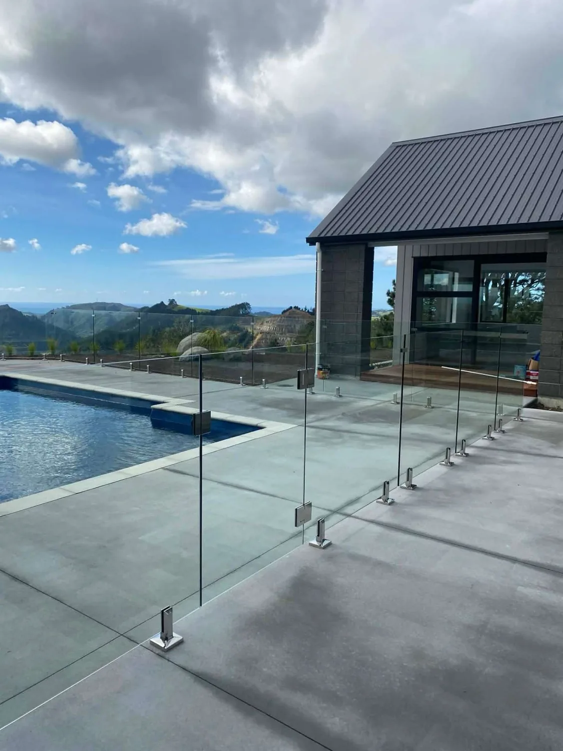 Glass pool fencing beside a paved pool surround