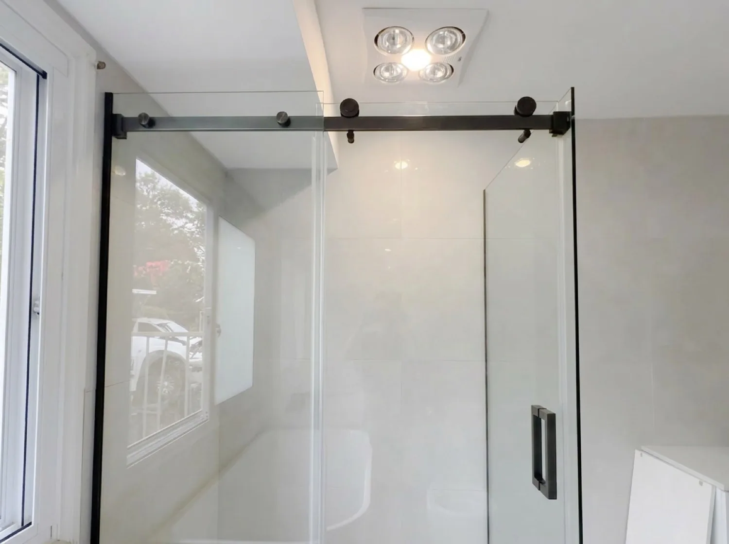 Sliding glass shower screen with black hardware in Tauranga